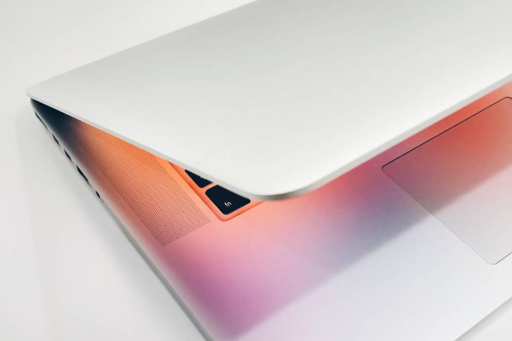 Laptop với màn hình hiển thị gradient màu cam, hồng và tím - công cụ nghiên cứu sản phẩm Amazon FBA